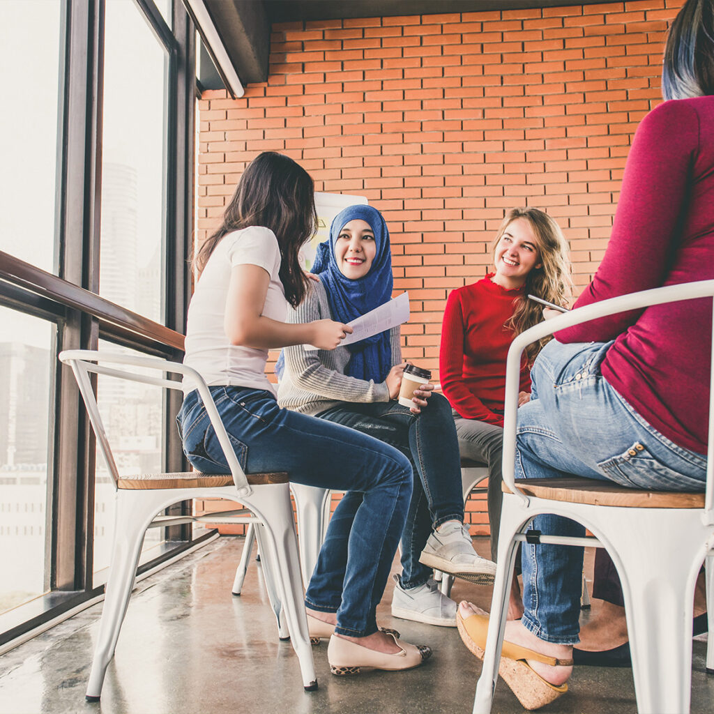 people sitting in a circle of chairs in a classroom setting learning about something