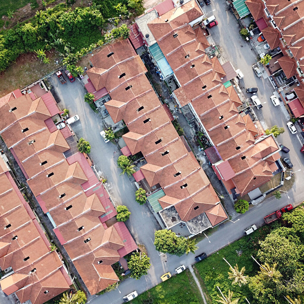 an arial photo of a housing complex with cars parked around the property and trees lining the edges