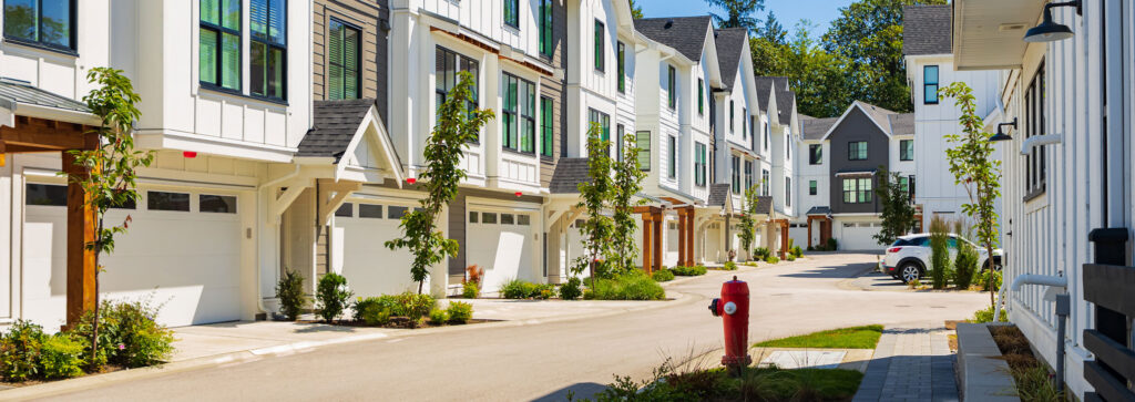 A row of condos with garages on the ground floor and living quarters above